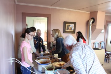 Madison Germann serves food to Cheryl Van Daele and senior member Howard Merz.