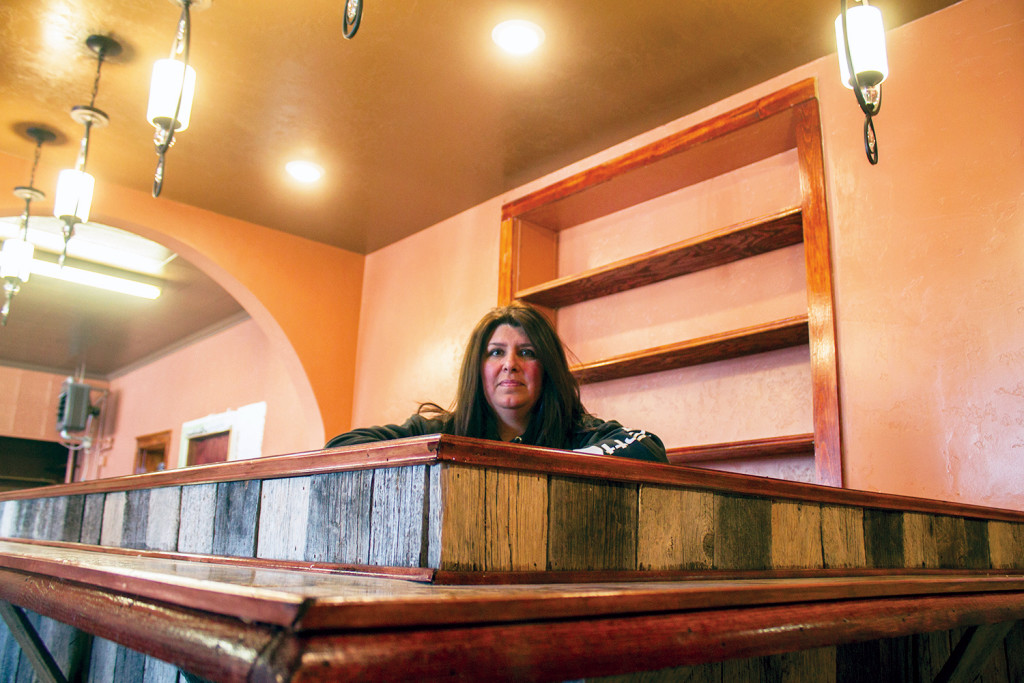 Barb Swanke of Marmarth is eager to open the doors of her new restaurant, Selena’s, on Main Street in Bowman. She rests against the recently added bar made of reclaimed wood from her ranch. (Photo by Bryce Martin/Pioneer)