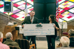 Justin Wolbaum of Dakota Community Bank presents a $200,000 check to Becky Hansen, CEO of Southwest Healthcare Services, for the new hospital building project. (Pioneer Photo by Bryce Martin)