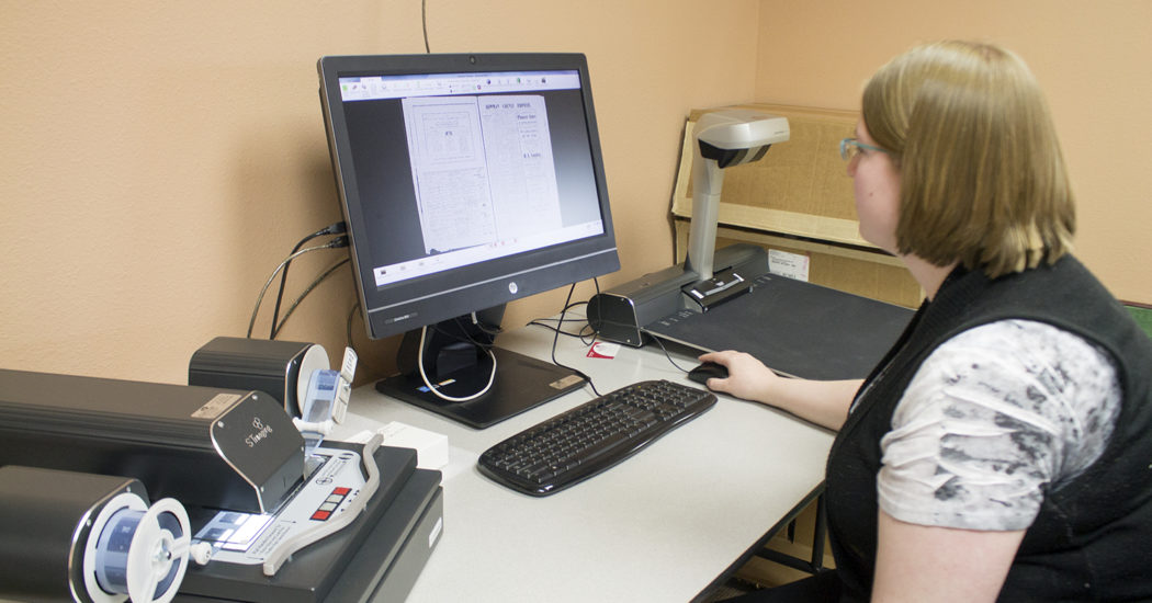 Pioneer Trails Regional Museum Administrator Jean Nudell using the museum’s new imaging scanner. (Pioneer File Photo)