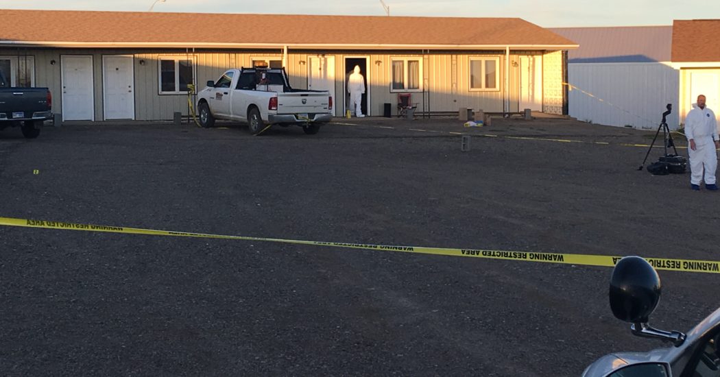 Crews from the North Dakota Bureau of Criminal Investigation examine at room Saturday at the El-Vu Motel in Bowman, wearing white forensics suits. (Pioneer Photo by Bryce Martin)