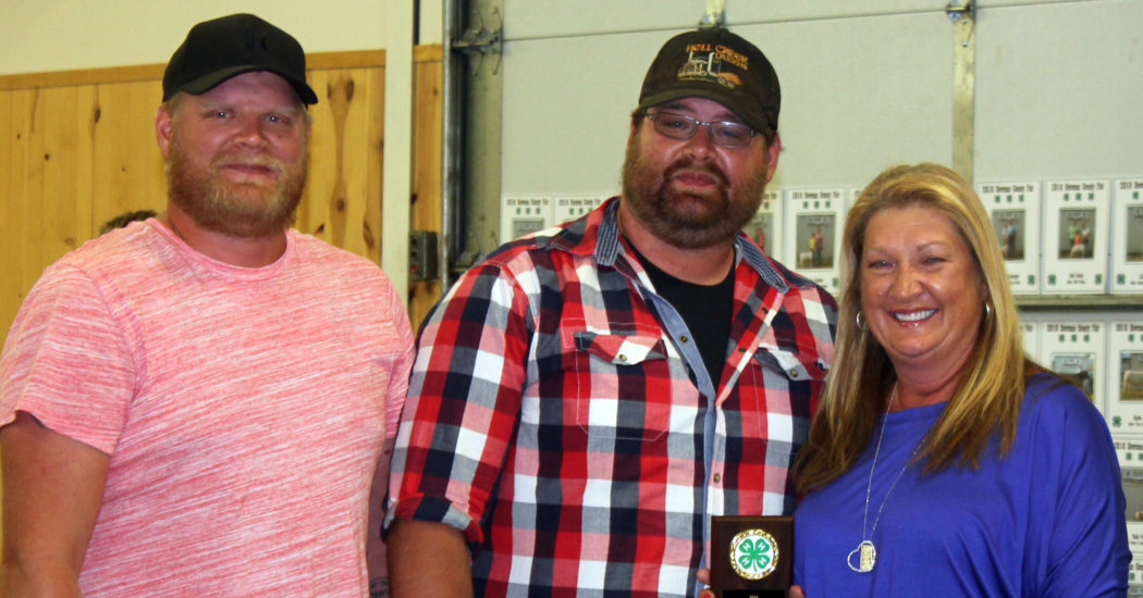 Denise Fischer accepts the 4-H honor for her late husband, Jim, along with her sons, Chris and Jason Fischer.