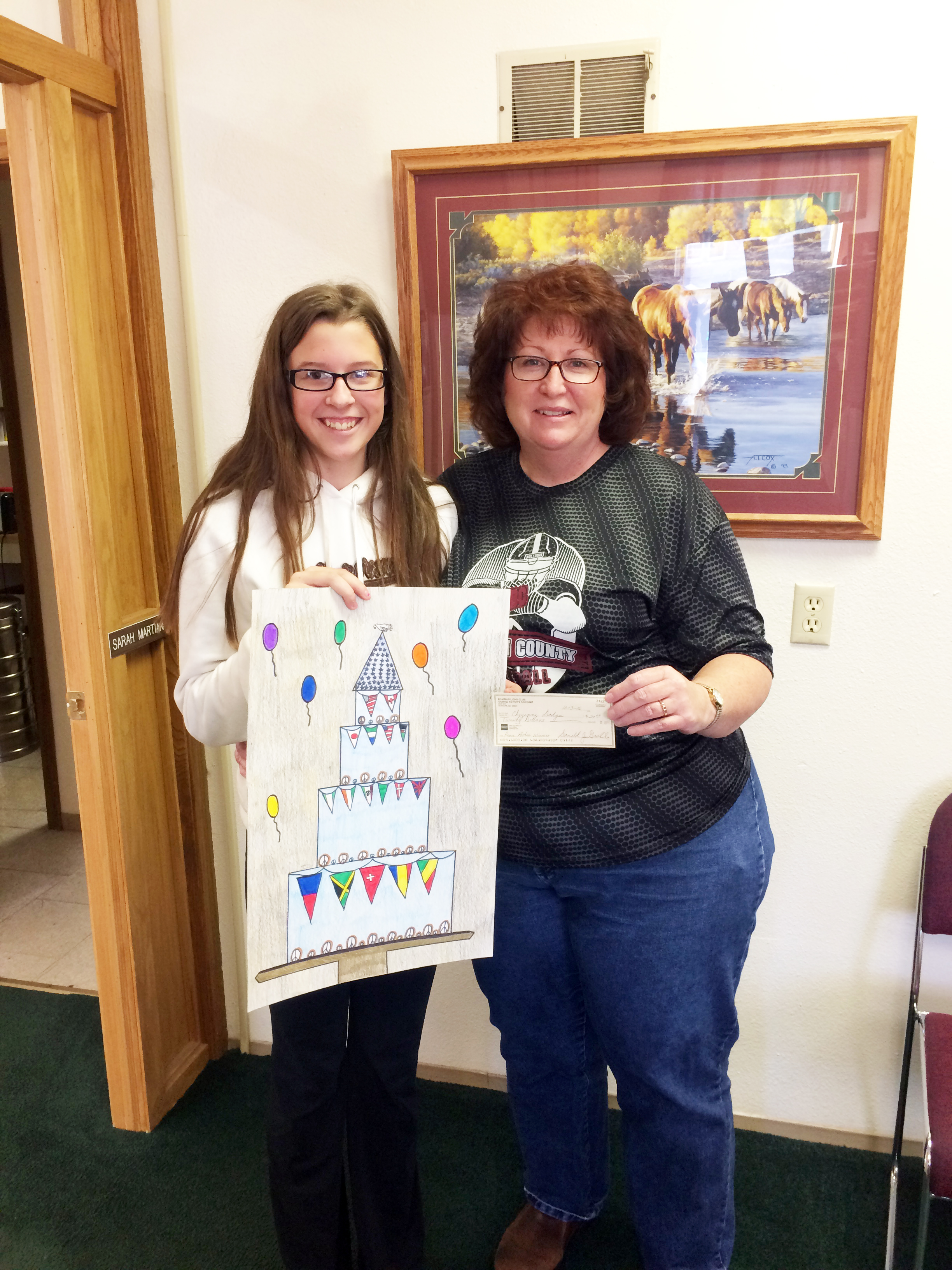 Cheyenne Dodge, a seventh grade student at Bowman County Schools, stands with Bowman Lions President Sandy Phelps as the winner of this year’s Bowman Lions Peace Poster Contest.